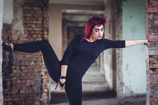 girl model in black with pink hair in an abandoned building