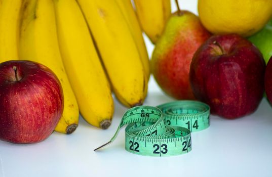 Set of fresh fruits, healthy fruits with measuring tape on white background. Diet concept