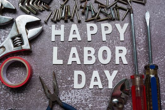 Happy labor day text with repair equipment and many handy tools on grunge grey concrete background