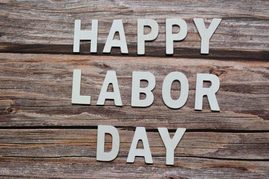 Happy labor day text on wooden table background