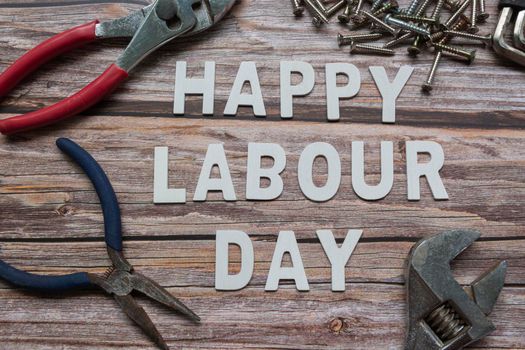 Happy labor day text with repair equipment and many handy tools on wooden background